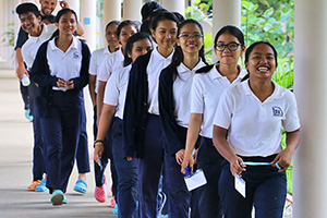 JPA Image Gallery - High school students smiling as they are caught by the camera on their way down the corridor - Jay Pritzker Academy, Siem Reap, Cambodia