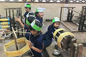 JPA Image Gallery - Kindergarten students check out silk thread while on their field trip to the silk farm - Jay Pritzker Academy, Siem Reap, Cambodia