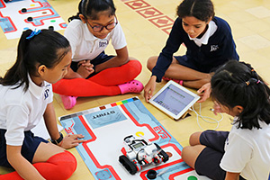 JPA Image Gallery - A group of Grade 5 students sit on the floor together as they consider their robotics task - Jay Pritzker Academy, Siem Reap, Cambodia