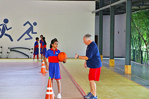 JPA Image Gallery - Physical education teacher explaining activity at the gym - Jay Pritzker Academy, Siem Reap, Cambodia