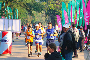 JPA Image Gallery - Team JPA students and teacher running at Angkor Wat International Half Marathon while crowds watch - Jay Pritzker Academy, Siem Reap, Cambodia