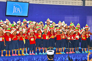 JPA Image Gallery - Preschool students wearing elf hats sing at assembly - Jay Pritzker Academy, Siem Reap, Cambodia