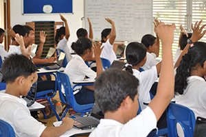 JPA Image Gallery - Students raise their hands at their desks - Jay Pritzker Academy, Siem Reap, Cambodia