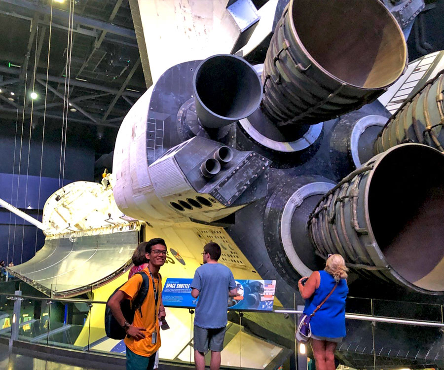 JPA student Savong ’18 with the NASA Space Shuttle Atlantis at the Kennedy Space Center, Cape Canaveral, Florida. Jay Pritzker Academy, Siem Reap, Cambodia. Jay-Pritzker-Academy-Siem-Reap-Cambodia