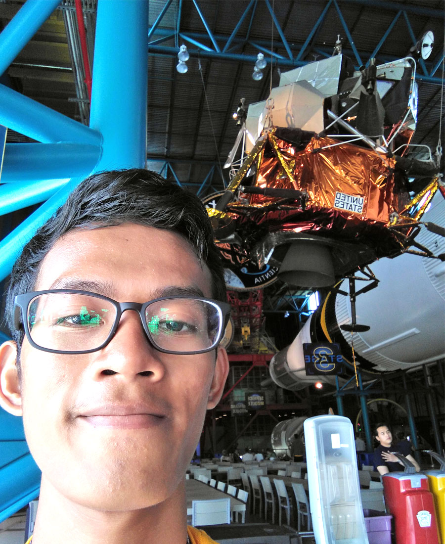 JPA student Savong ’18 with the Lunar Excursion Module LM9 for the Apollo 15 Mission at the Kennedy Space Center, Cape Canaveral. Jay Pritzker Academy, Siem Reap, Cambodia. Jay-Pritzker-Academy-Siem-Reap-Cambodia