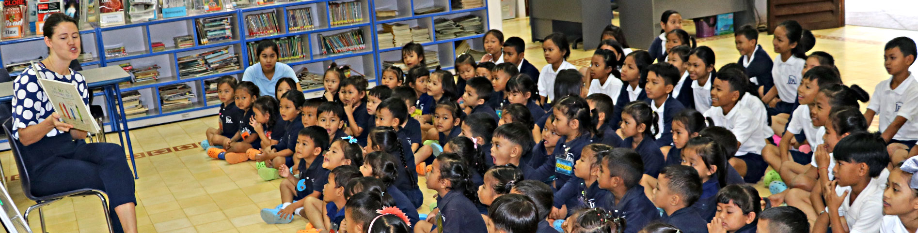 JPA students listening to a JPA Teacher read a story in the library for Book Week. Book: The Day the Crayons Quit. Jay Pritzker Academy, Siem Reap, Cambodia. Jay-Pritzker-Academy-Siem-Reap-Cambodia.